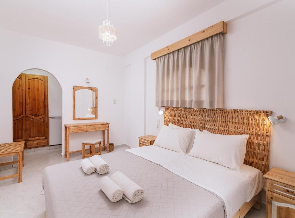 a bedroom with a large white bed with towels on it at Amalia in Matala