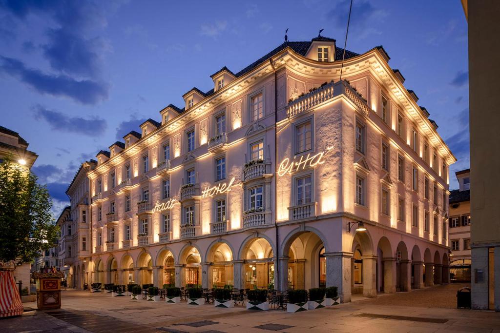 ein großes weißes Gebäude mit Beleuchtung in der Unterkunft Stadt Hotel Città in Bozen