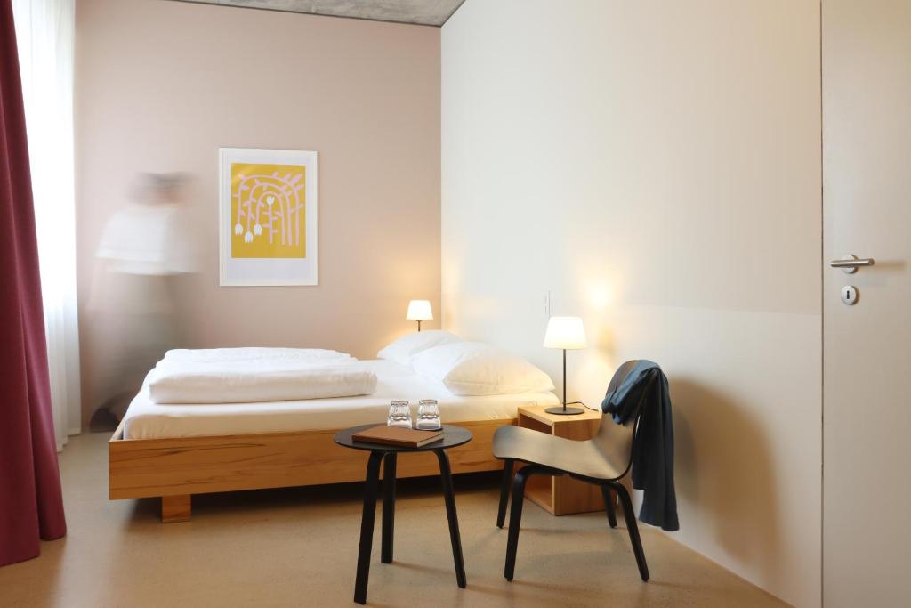 a hotel room with a bed and a desk at Guesthouse Kalkbreite in Zurich