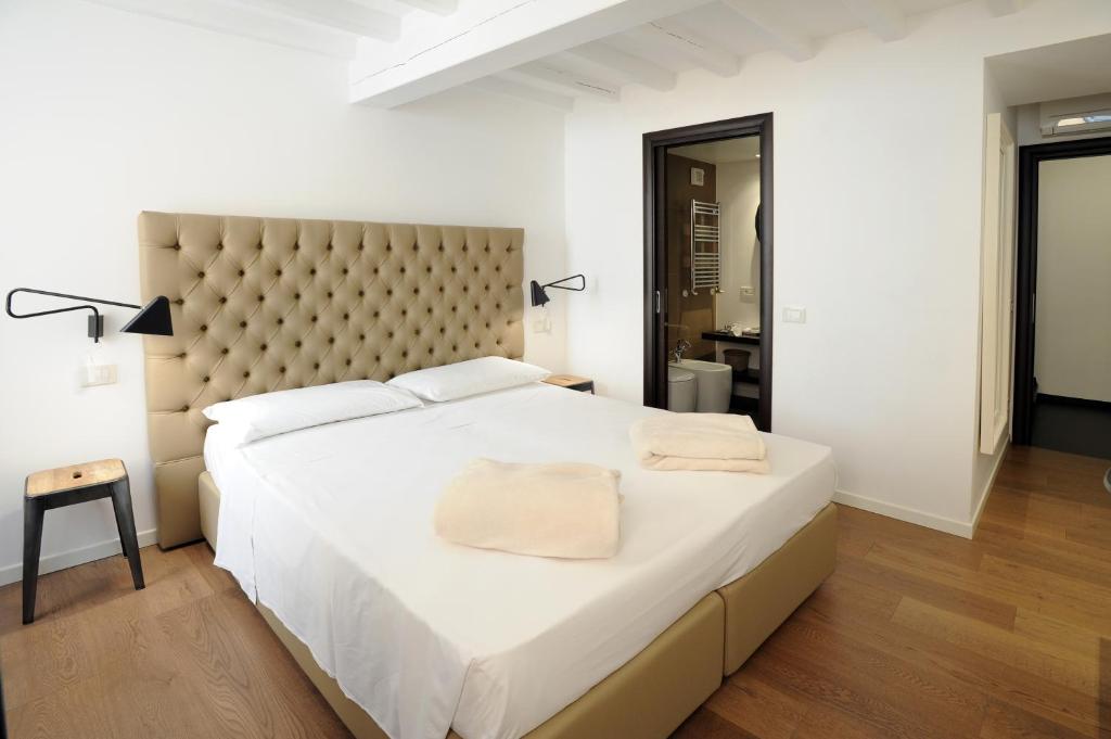 una camera da letto con un grande letto bianco con una grande testiera del letto di Opera 11 r&b a Parma