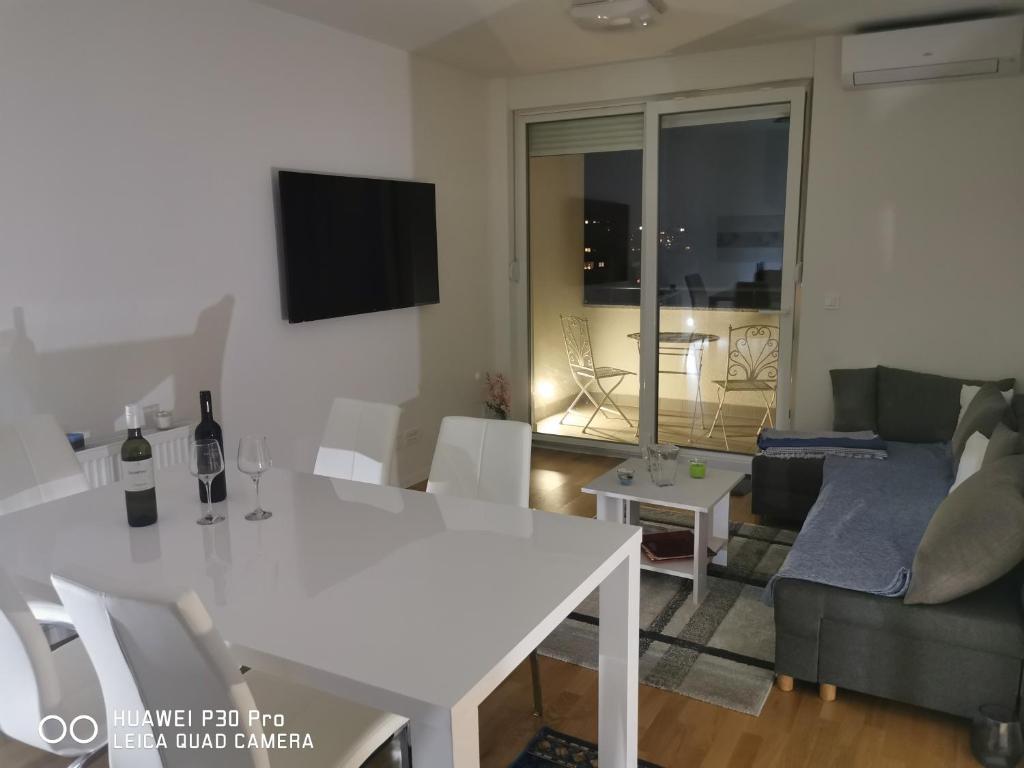a living room with a white table and a couch at CITY CENTER PEARL #new#free reserved parking in garage elevator direct access#business and pleasure#city view&balcony&sunny&cafes&markets&tram#city center in Zagreb