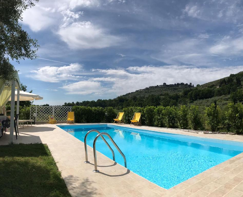 a large swimming pool with two yellow chairs next to it at Oasi naturale "Roscignola" in SantʼOnofrio