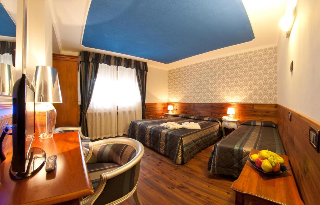 Pokój hotelowy z 2 łóżkami i biurkiem w obiekcie Hotel Cles w mieście Cles