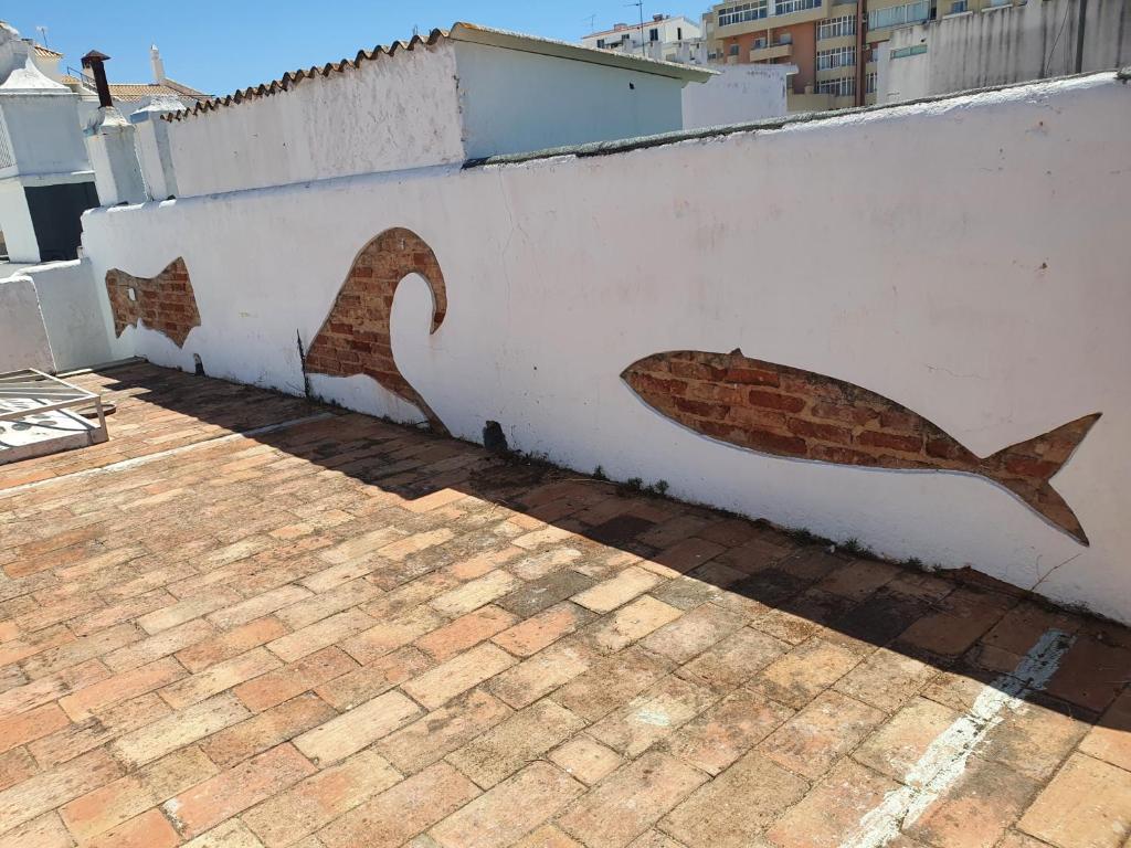 a fish painted on the side of a wall at Baixa Terrace Hostel in Faro