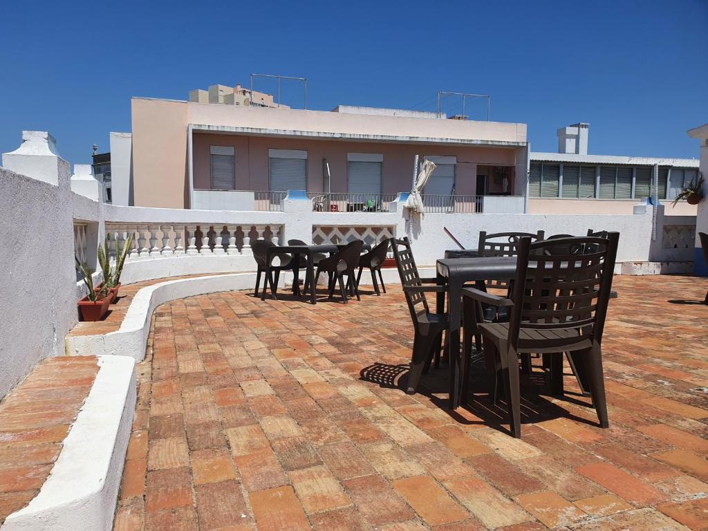 a patio with tables and chairs on a roof at Baixa Terrace Hostel in Faro