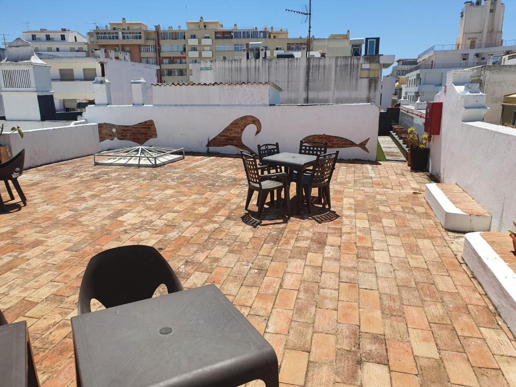 a patio with a table and chairs on a roof at Baixa Terrace Hostel in Faro