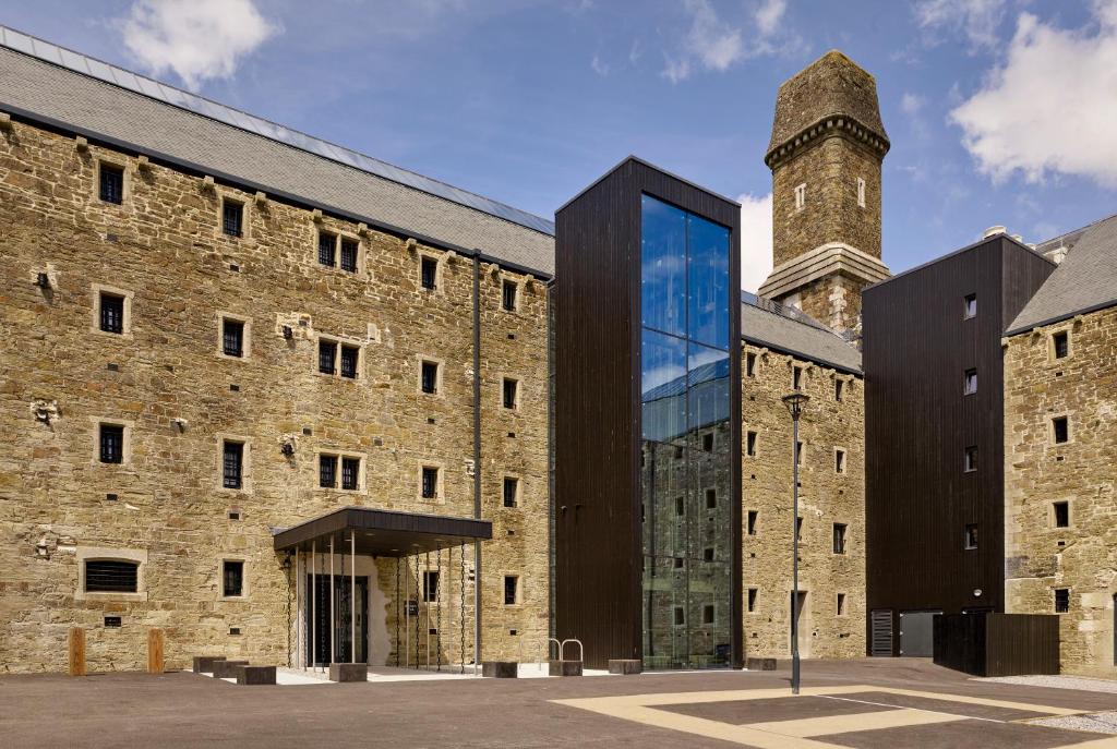 un grand bâtiment en briques avec un mur en verre dans l'établissement Bodmin Jail Hotel, à Bodmin