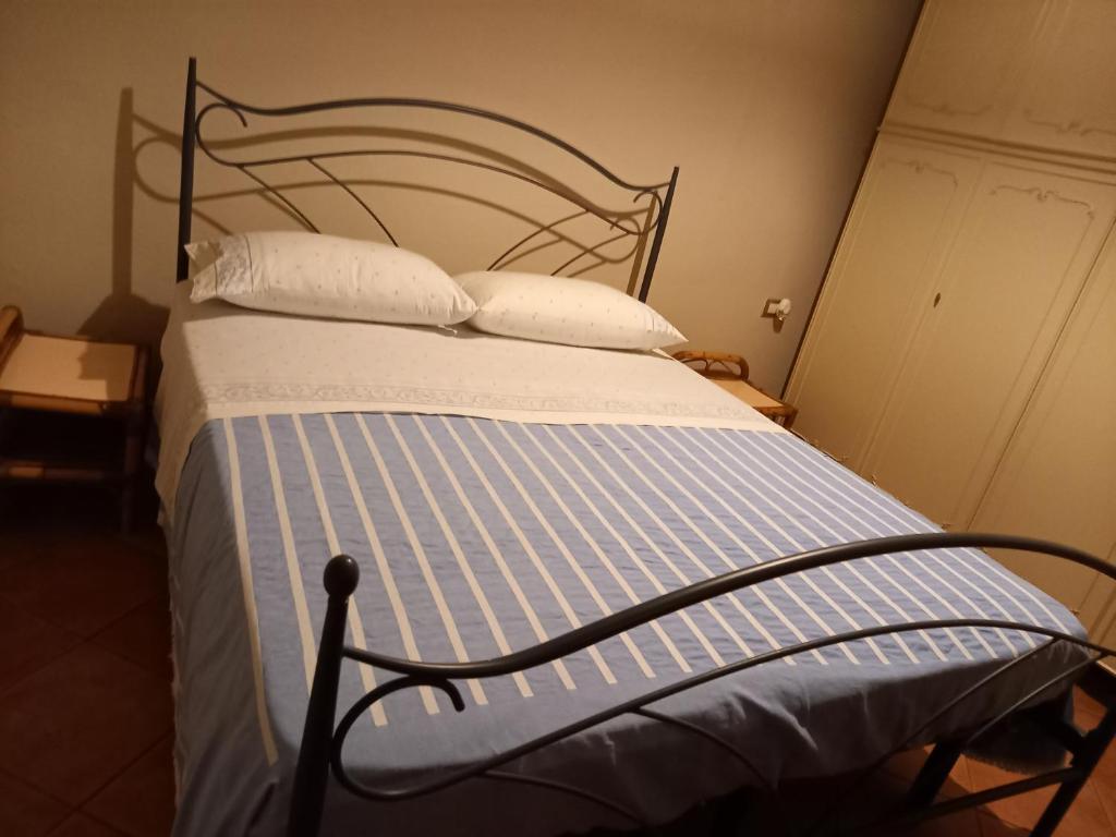 - un lit avec des draps et des oreillers bleus et blancs dans l'établissement Marameo b&b, à Caorso