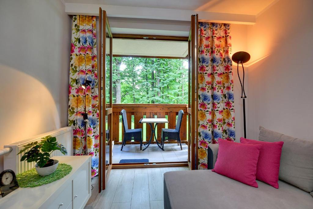 sala de estar con sofá y mesa con sillas en Apartamenty Sun Seasons 24 - Leśny Dom, en Karpacz