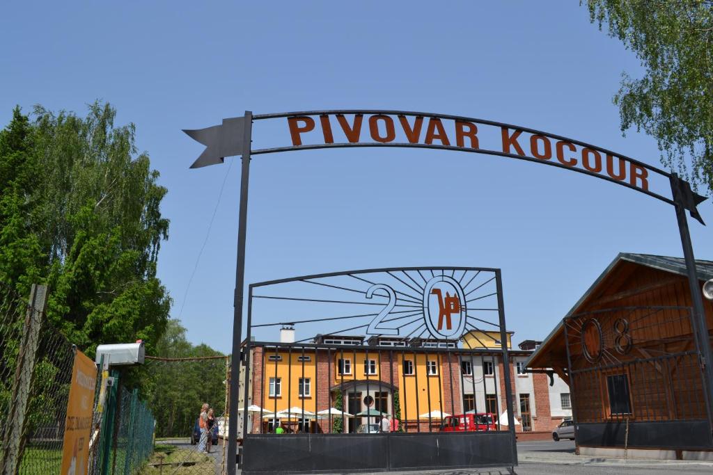 un panneau devant un bâtiment jaune dans l'établissement Pivovar Kocour, à Varnsdorf