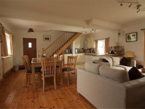 a living room with a couch and a table with chairs at Jurassic Apartments in Weymouth