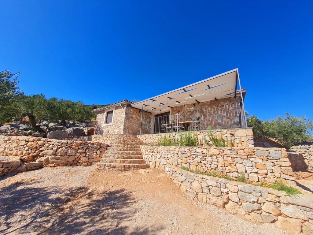 a stone house with a stone wall and stairs at Luxury stone house in a Nature park in Sali