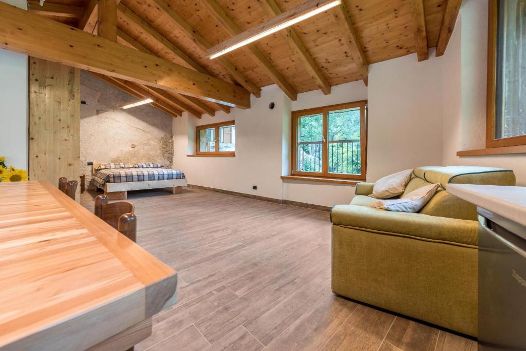 salon z kanapą i stołem w obiekcie Casa al mulino w mieście Tenno