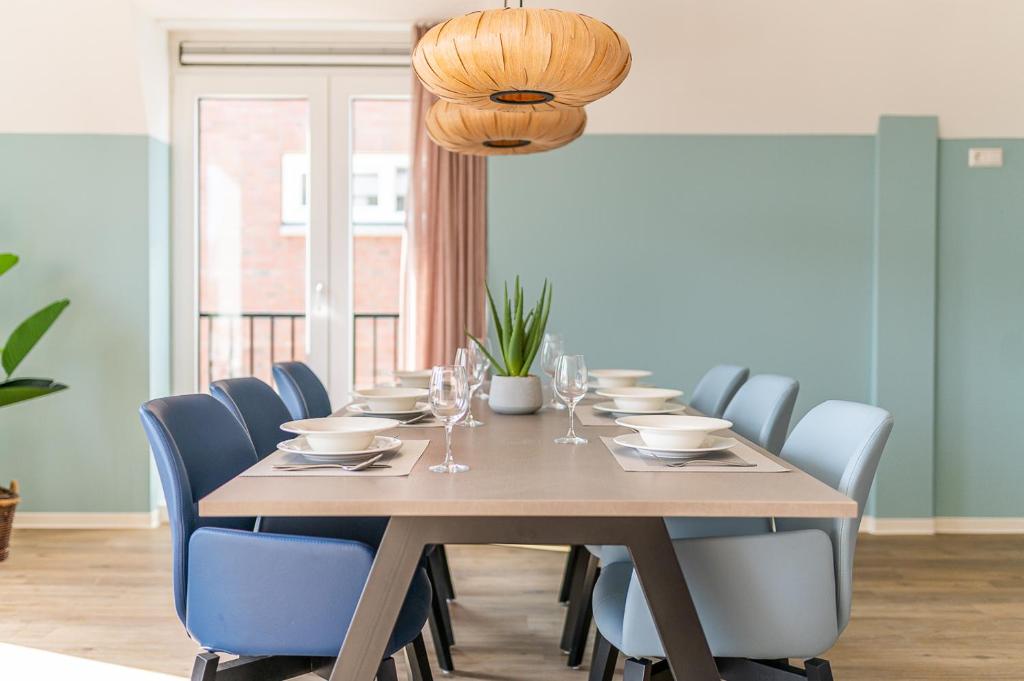 a dining room with a wooden table and blue chairs at Boutique resort Schaardijk vakantieappartement in Scharendijke