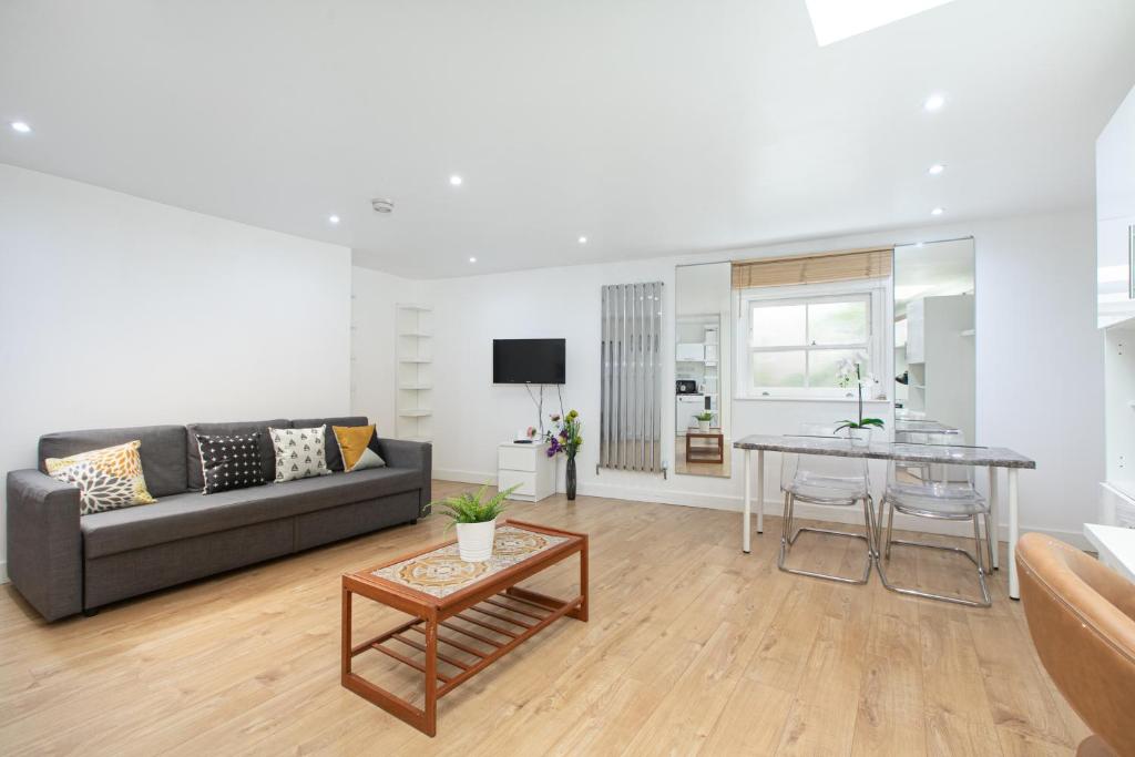 a living room with a couch and a table at Skyvillion - One Bedroom Apartment by London King's Cross in London