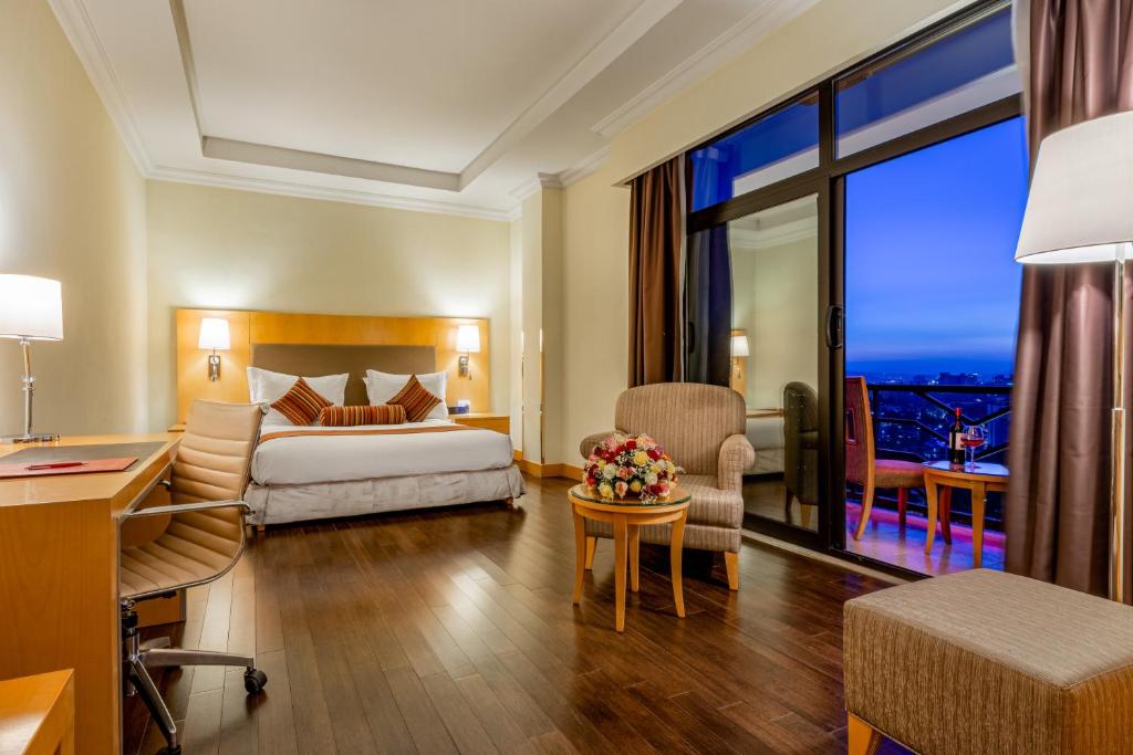 - une chambre d'hôtel avec un lit et un bureau dans l'établissement Ramada Addis, Addis Ababa, à Addis-Abeba