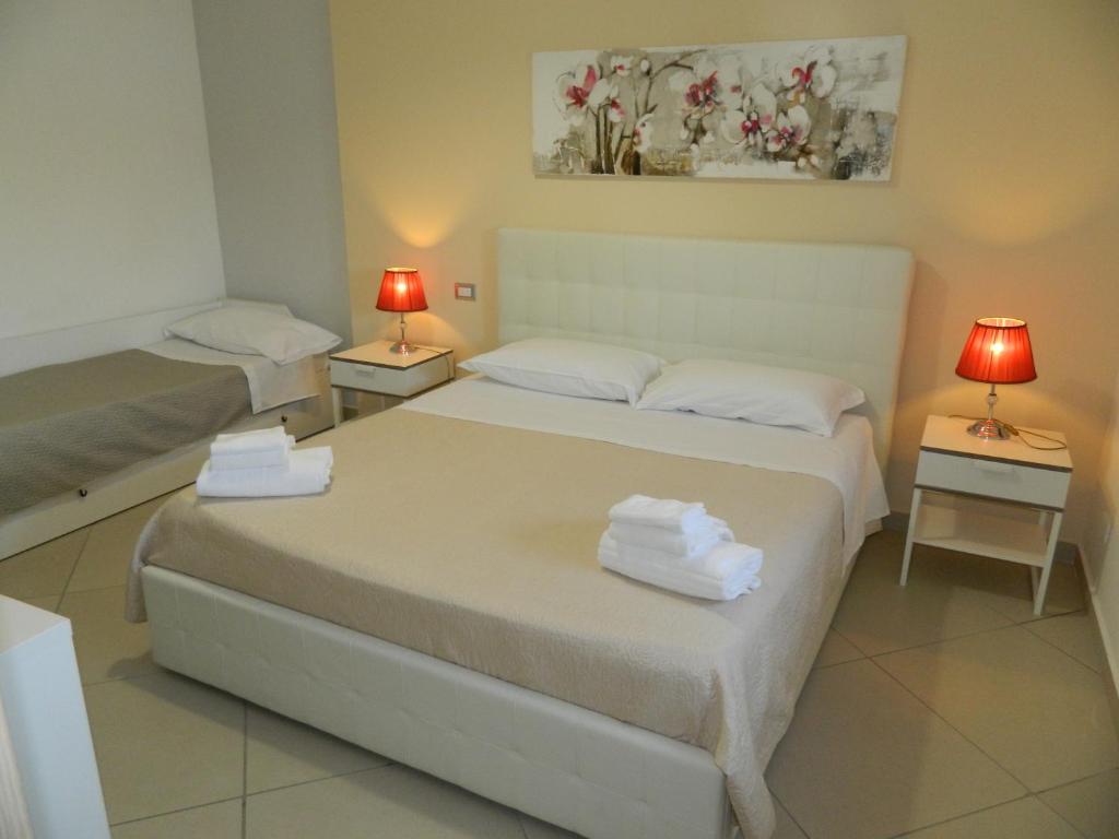 a bedroom with two beds and two tables with lamps at A Casa di Anna - Locazione Turistica - in Matera