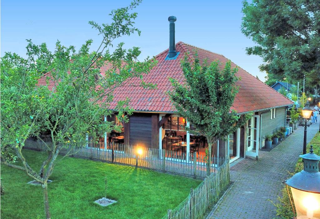 una casa con techo rojo y valla en Hotel Hof van 's Gravenmoer, en 's-Gravenmoer