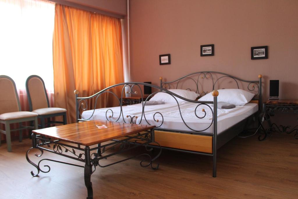 a bedroom with a bed and a coffee table at Hotel Tara in Nyíregyháza