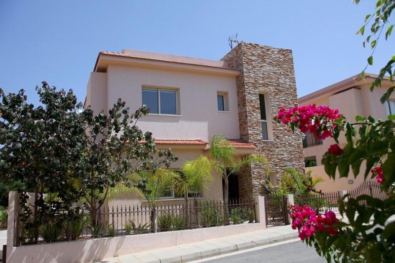 una casa grande con una valla y flores rosas en Michelle 8, en Protaras