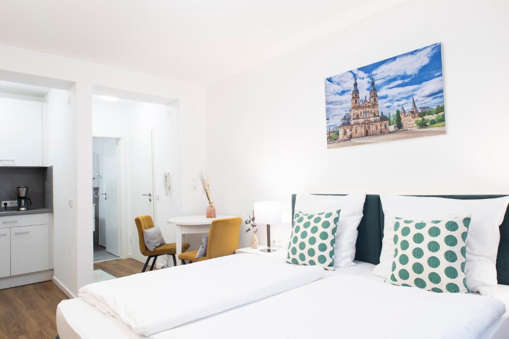 a white bedroom with a bed and a table at Leben im Herzen von Fulda in Fulda