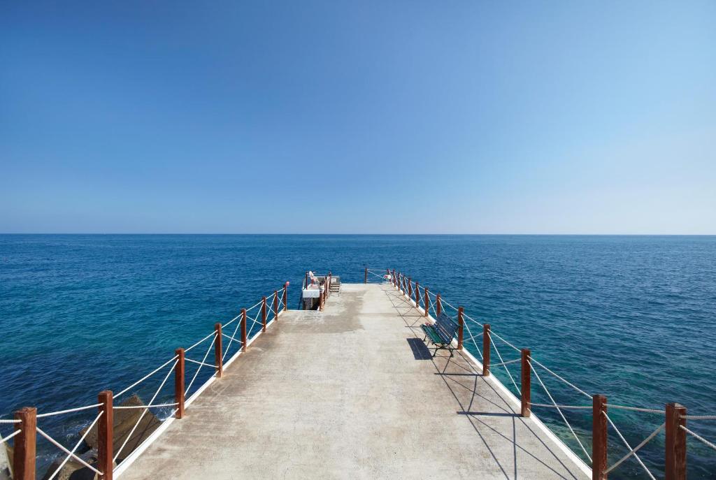 a pier in the middle of the ocean at The Cliff Bay - PortoBay in Funchal