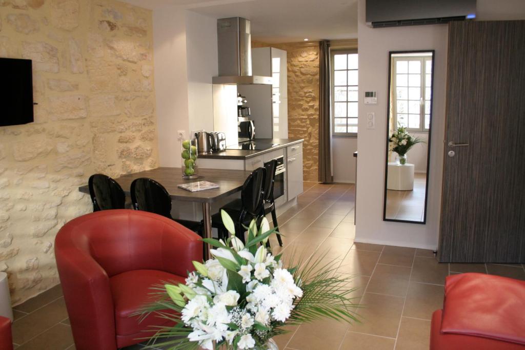 cocina y sala de estar con mesa y sillas en Le Porche de Sarlat, en Sarlat-la-Canéda