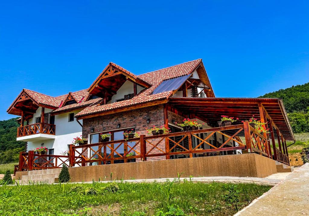 ein großes Haus mit rotem Dach in der Unterkunft Pensiunea Balkan in Gornea