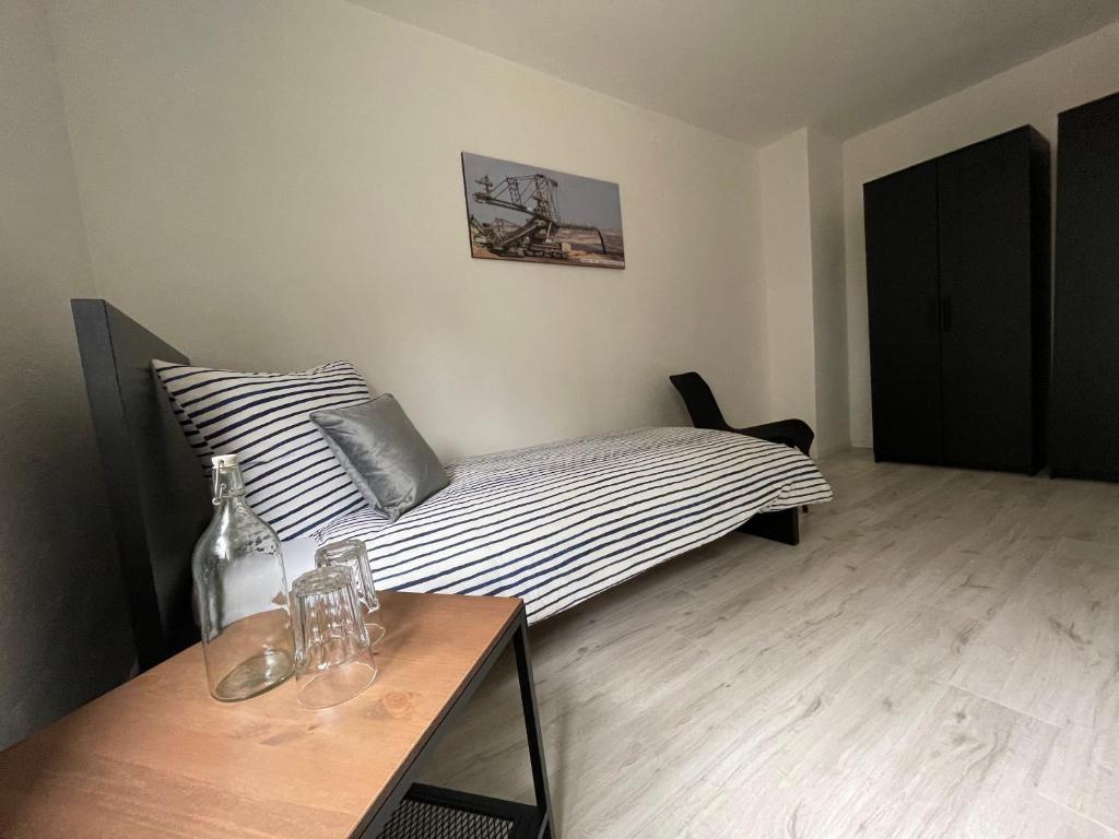 a bedroom with a bed and a table with a bottle at Modernes Business Apartment für Geschäftsreisende, Monteure, Handwerker in Burgneudorf