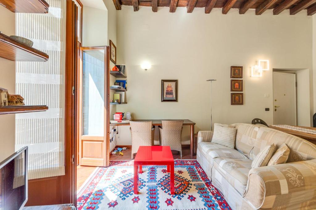 een woonkamer met een bank en een rode tafel bij Easylife - Classic Flat in Corso Como in Milaan