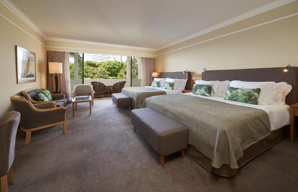 a hotel room with two beds and a living room at The Cliff Bay - PortoBay in Funchal