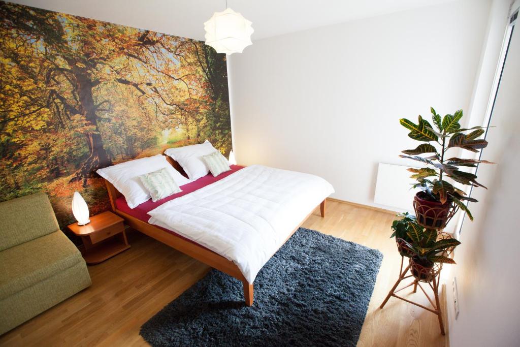 プラハにあるAngel Apartmentsのベッドルーム1室(壁に絵画が描かれたベッド1台付)