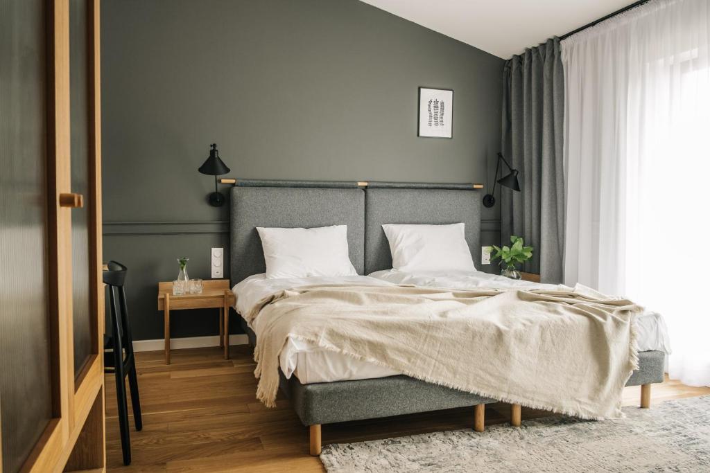 a bedroom with a large bed and a gray wall at Apartamenty Las in Radomsko