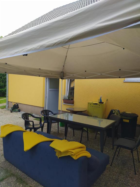 a patio with a table and chairs under a tent at SŁONECZNIK in Rewal