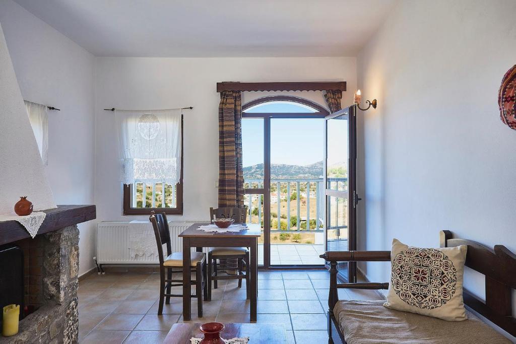 ein Wohnzimmer mit einem Tisch und ein Esszimmer in der Unterkunft Lasinthos Eco Park in Agios Georgios