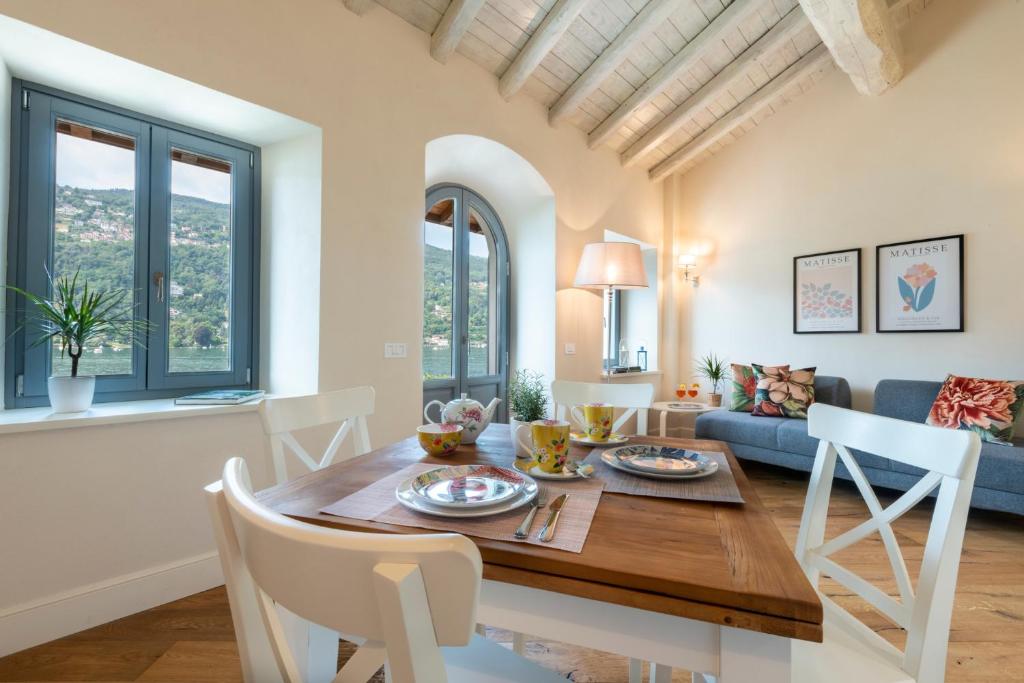 a kitchen and living room with a wooden table and chairs at Isola Bella Apartments Via Vittorio Emanuele in Stresa