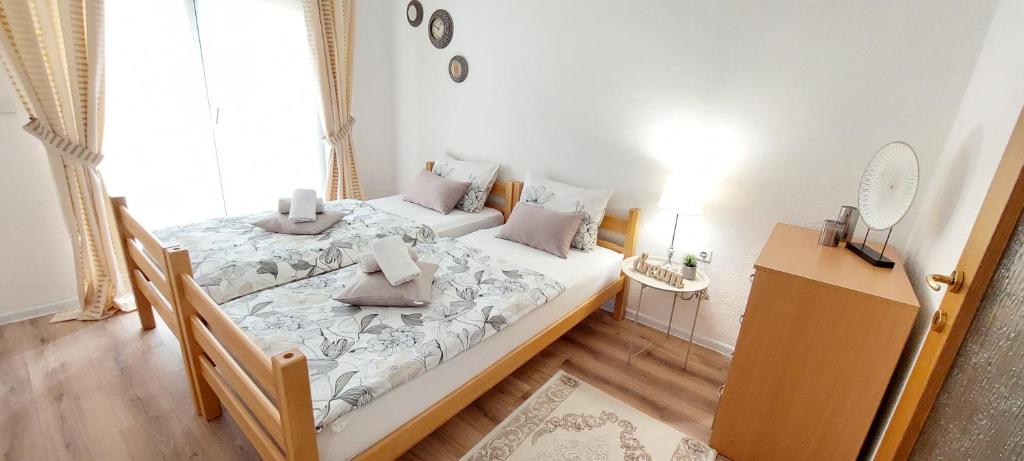 1 dormitorio con 2 camas y espejo en la pared en MB Deluxe Apartment, en Visoko