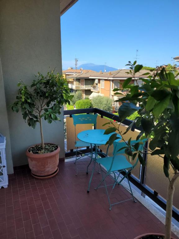 balcón con mesa, sillas y plantas en Garda Best Living, en Desenzano del Garda