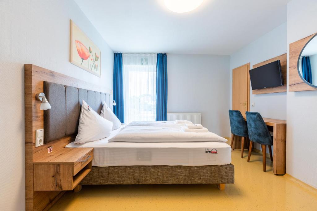 ケルンにあるHotel Arenaのベッドと机と椅子のある寝室