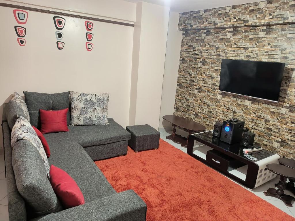 a living room with a couch and a flat screen tv at Jayson Furnished Apartment, Nairobi in Nairobi
