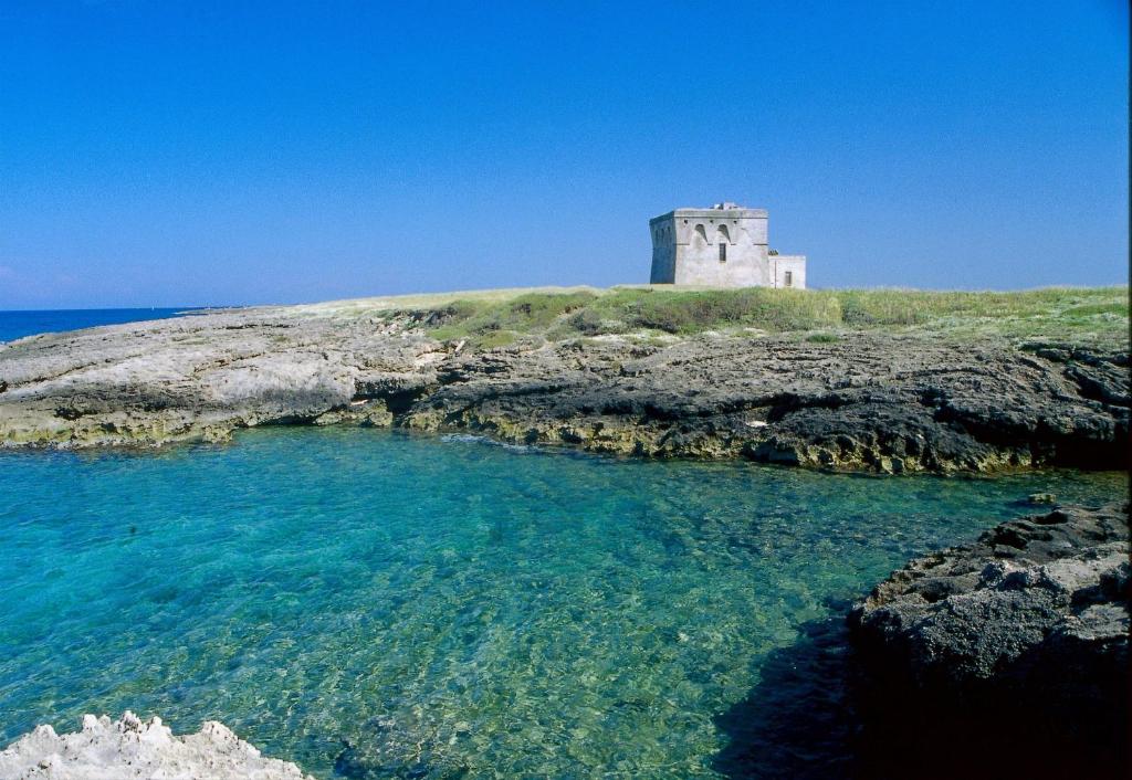a lighthouse on top of an island in the ocean at Casa Mediterranea Jacuzzi riscaldata con Caminetto in Specchiolla