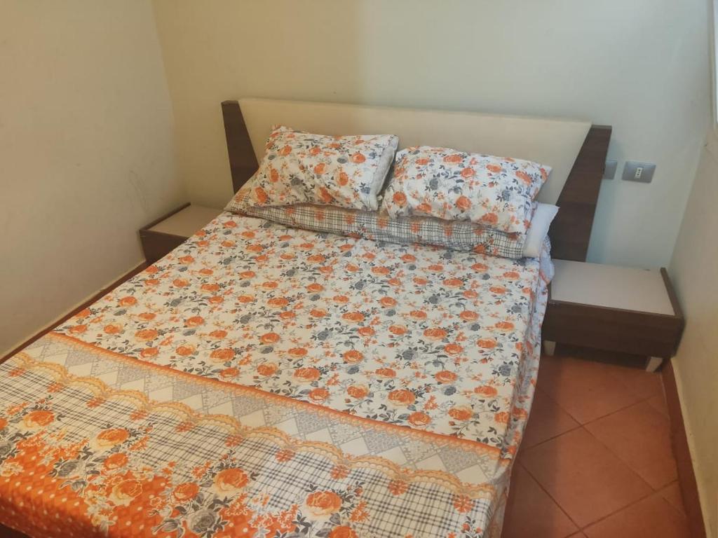 a bed with a quilt and two pillows on it at one bedroom chalet porto south Families only in Ain Sokhna