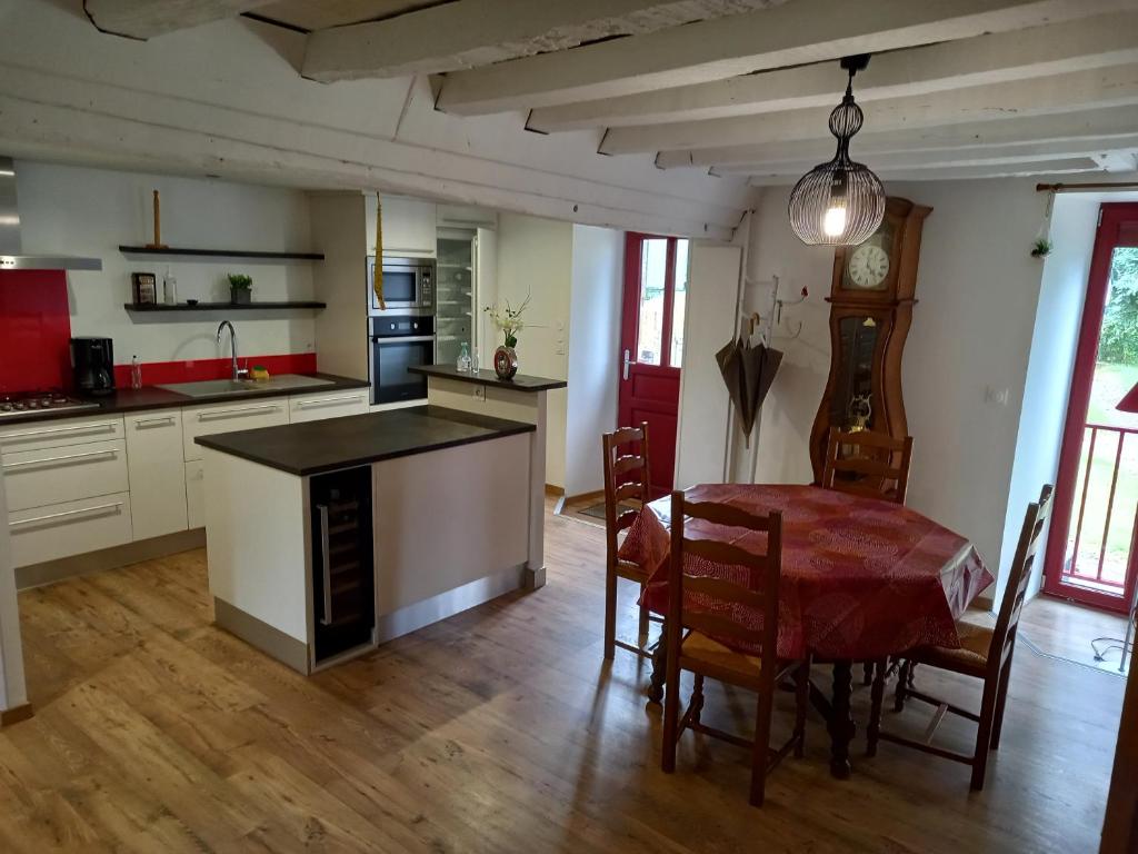 a kitchen and dining room with a table and chairs at Chez Jojo à St fraimbault in Saint-Fraimbault-de-Prières