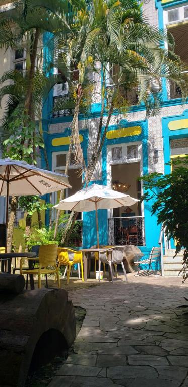 a patio with tables and umbrellas in front of a building at Antonieta Hostel in Belém