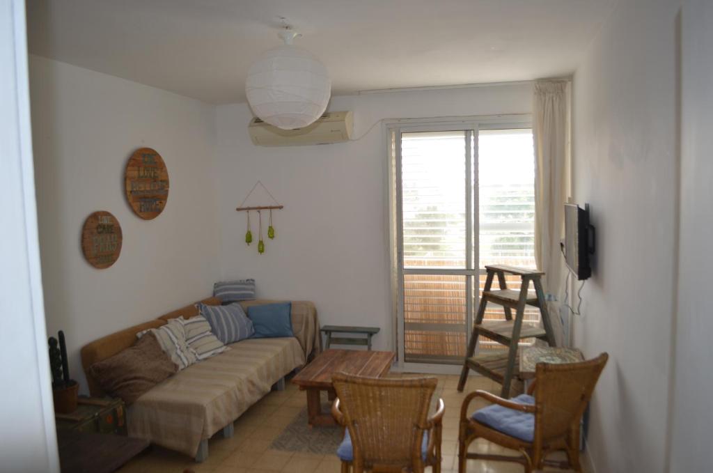 een woonkamer met een bank en een tafel en stoelen bij Jerusalem 18 in Akko