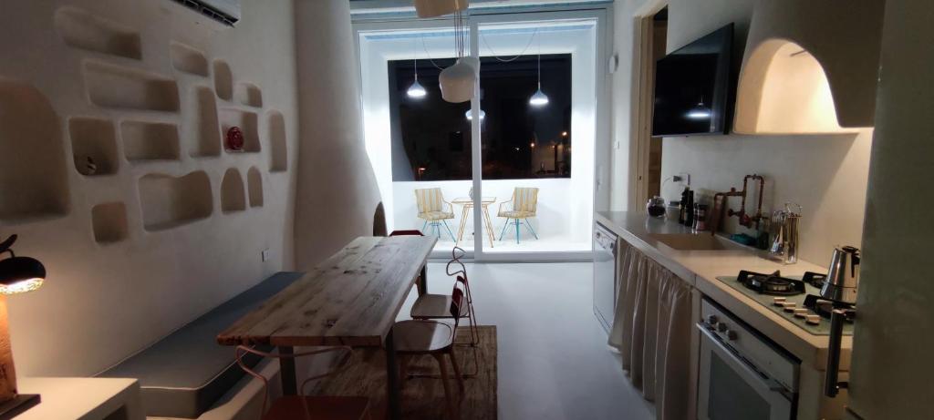 a kitchen with a wooden table and a window at Casa Mediterranea Jacuzzi riscaldata con Caminetto in Specchiolla