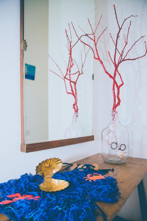 a wooden table with a vase with branches and scissors in it at Living Bouganville in Trapani