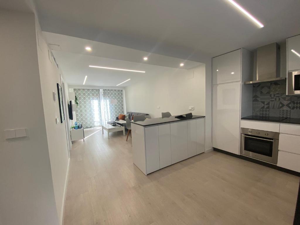 een keuken met witte kasten en een woonkamer bij Apartamento Andalucía Centro in Antequera