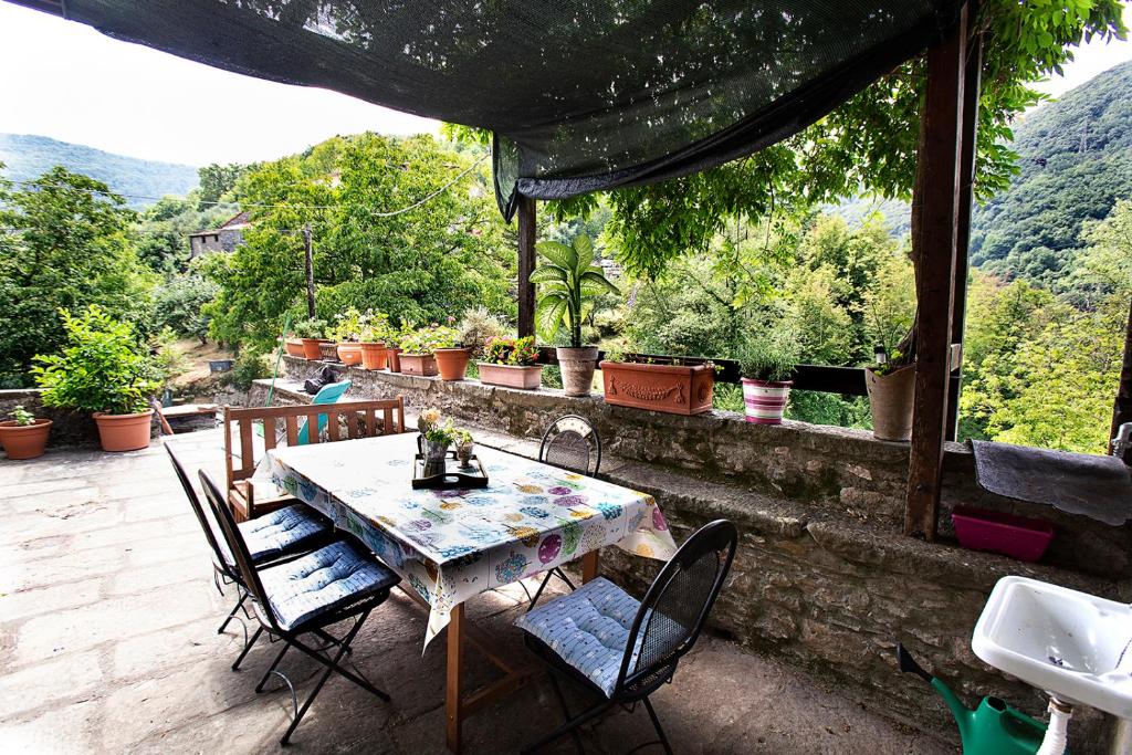 a table and chairs on a patio with a view at Castè Style Fam Holidays near Cinque Terre in Riccò del Golfo di Spezia