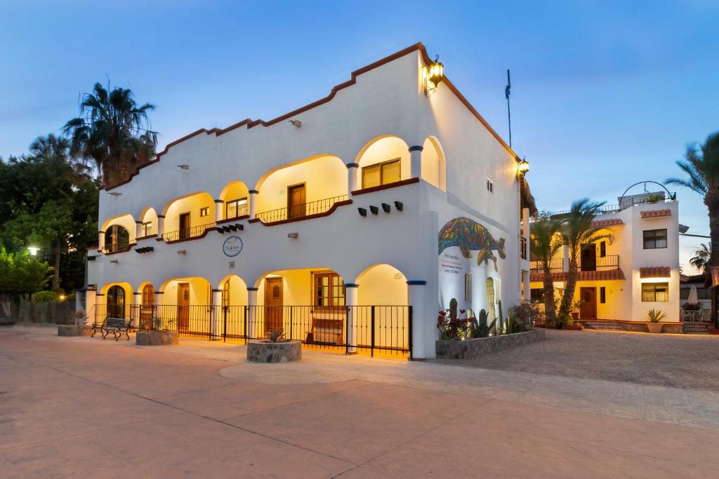 a large white building with a fence in front of it at Villas del Santo Niño in Loreto